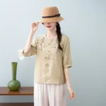⁦قميص نسائي صيفي قصير الأكمام بياقة دائرية من القطن والكتان، بتصميم كلاسيكي أنيق وفضفاض، مزين بتطريزات تُخفي علامات التقدم في السن.⁩ - الصورة ⁦5⁩