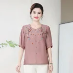 ⁦قميص نسائي صيفي قصير الأكمام بياقة دائرية من القطن والكتان، بتصميم كلاسيكي أنيق وفضفاض، مزين بتطريزات تُخفي علامات التقدم في السن.⁩ - الصورة ⁦10⁩